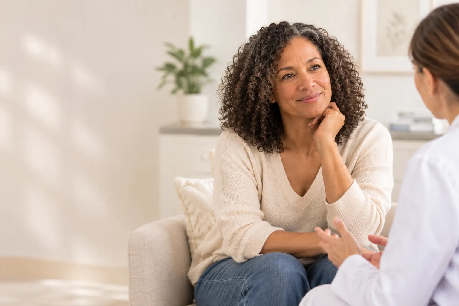 Woman with curly hair listening to a provider during a consultation